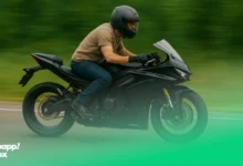 A man with a black helmet riding a black motorcycle fast