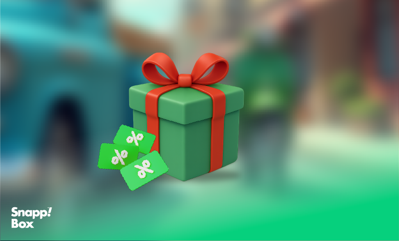 A green gift box with a red ribbon and 3 discount icons beside it