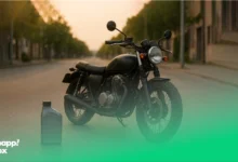 A black motorcycle with a can of motorcycle oil beside it