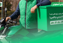 پیک اسنپباکس با لباس، موتور و باکس سبز در خیابانی در اصفهان