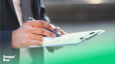 دستان یک مرد که یک چک‌لیست راه‌اندازی کسب‌وکار و یک خودکار را نگه داشته است