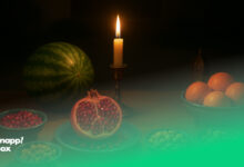 سفره‌ی یلدا شامل هندوانه، انار، آجیل، شمع و پرتقال